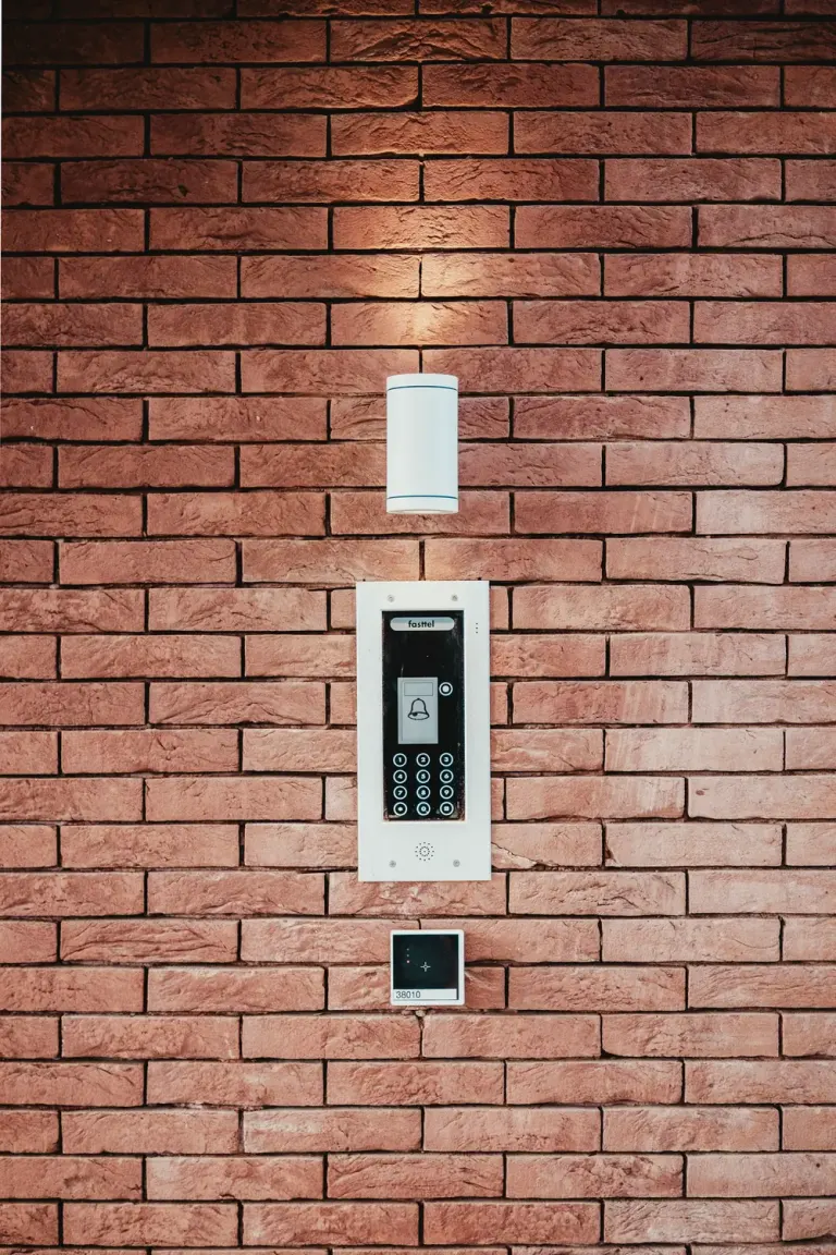 Security alarm keypad mounted on a brick wall