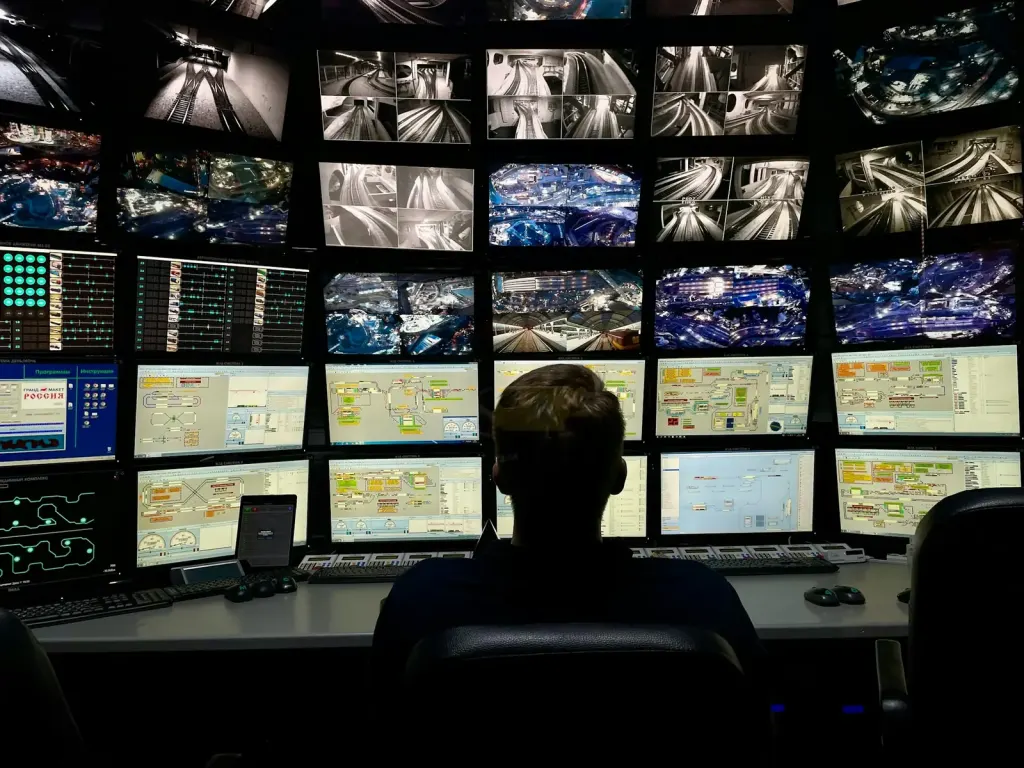 Security operator monitoring CCTV screens in a control room