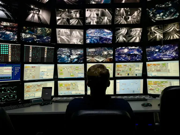 Security operator monitoring CCTV screens in a control room